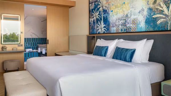 Hotel Ora’s 64sqm Deluxe Suite offers modern, spacious comfort with a king-sized bed, 75-inch smart TV, high-speed Wi-Fi, and connecting room options.